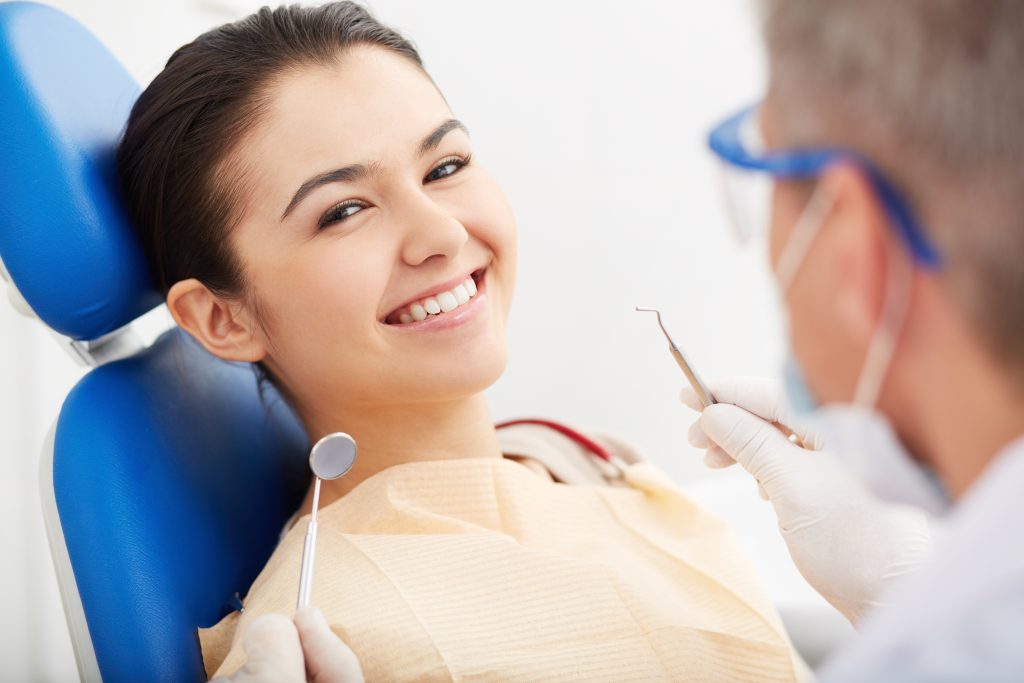 Image of smiling patient looking at camera at the dentist’s